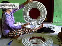 Women in Bali Indonesia working with sea shells and feather papua necklaces